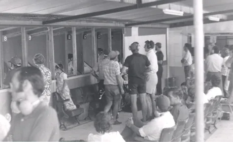 Shooters and spectators under the covered area behind the turning target range