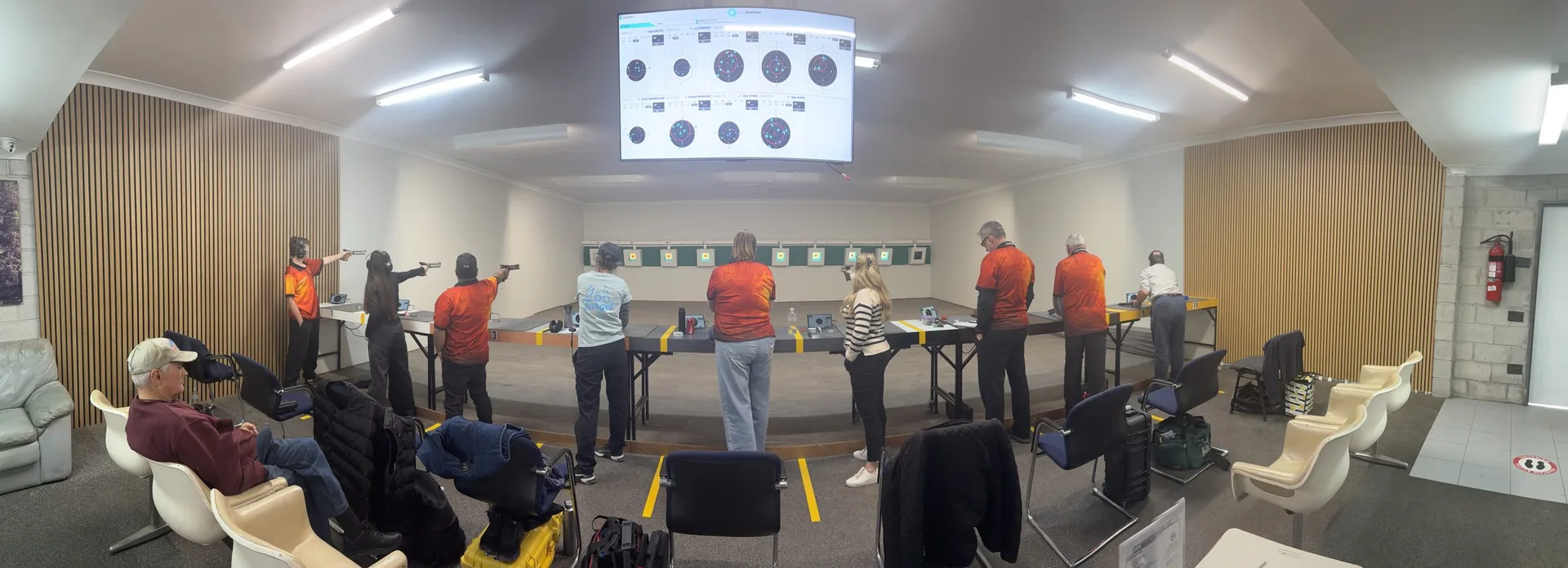 Shooters on the line at the CLDPC indoor air pistol range, under supervision