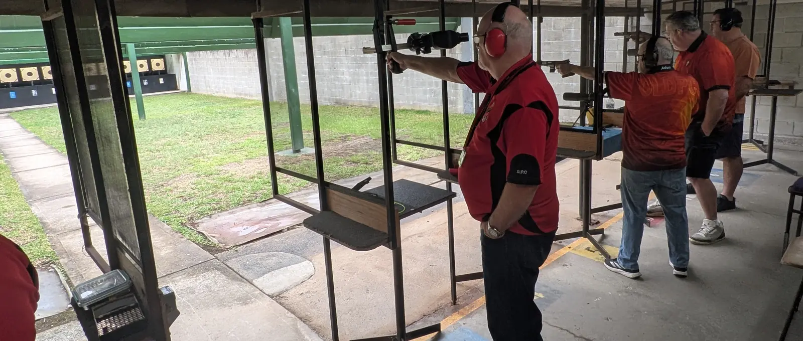Shooters on the covered outdoor firing line during a match